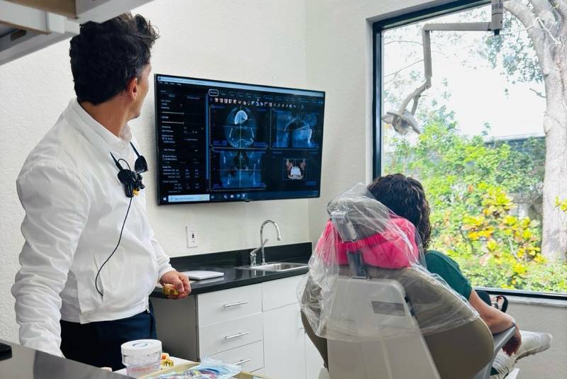 Dr. Macedo reviewing 3D imaging on screen with a patient in the chair
