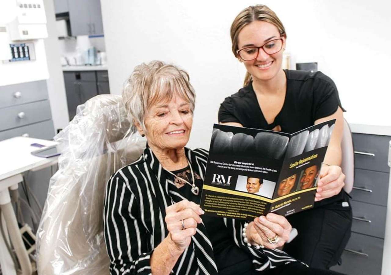 A patient reviewing her smile design plan chairside with the Advanced Center for Cosmetic Dentistry team